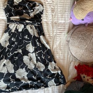 Black and white cocktail dress with flower design, also has a waist band.